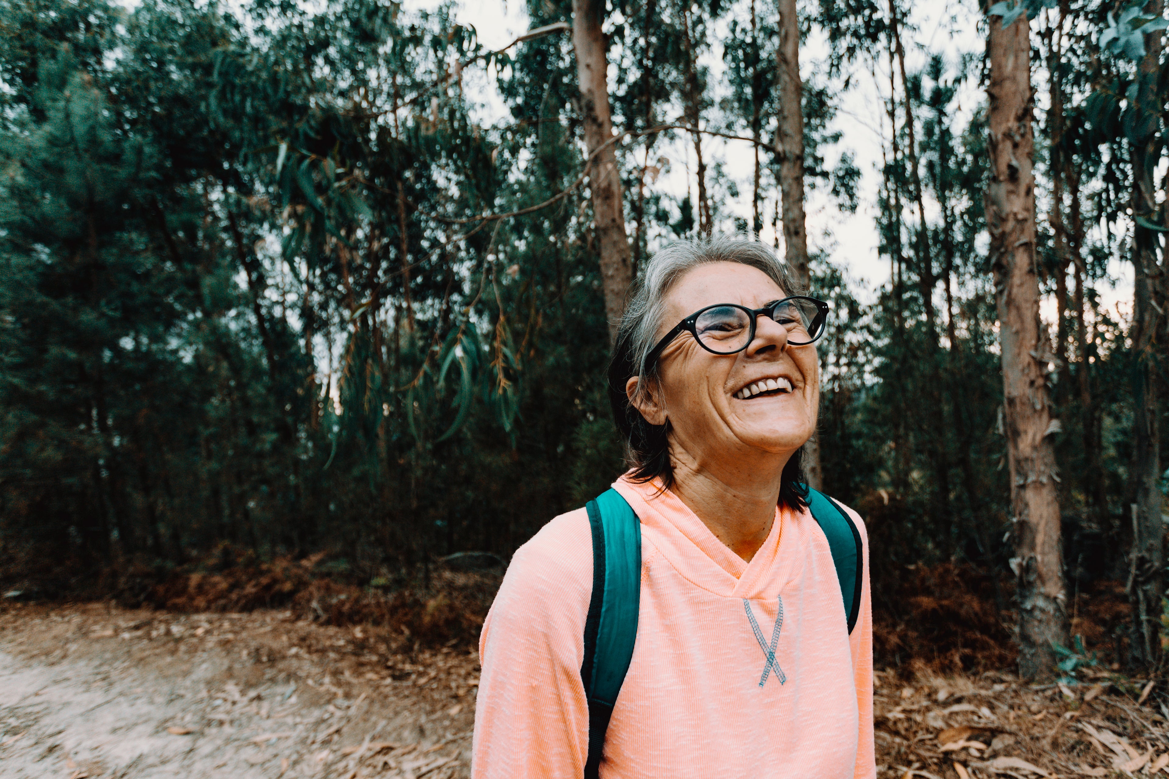 woman-tilts-her-head-back-and-smiles-outdoors - GiftImpact